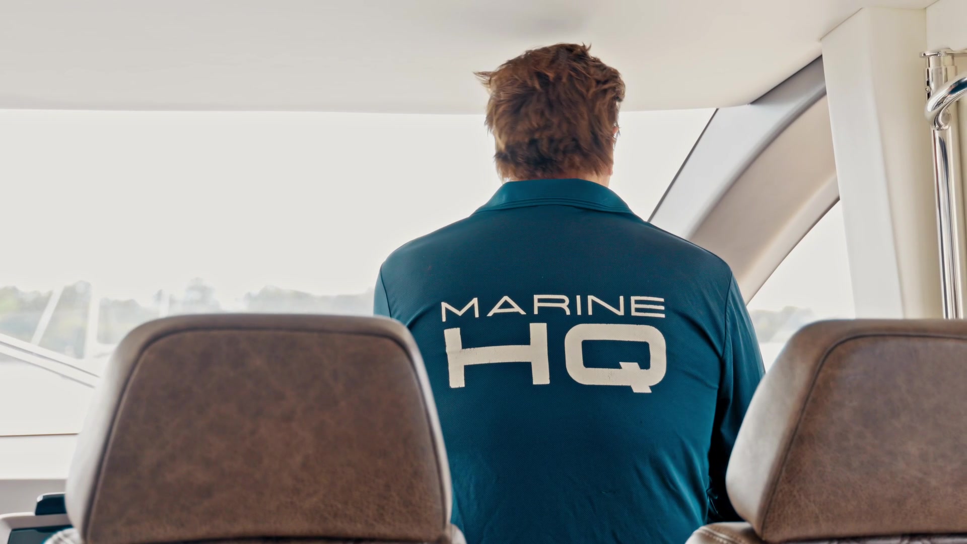 A skipper seated at the helm of a motor yacht